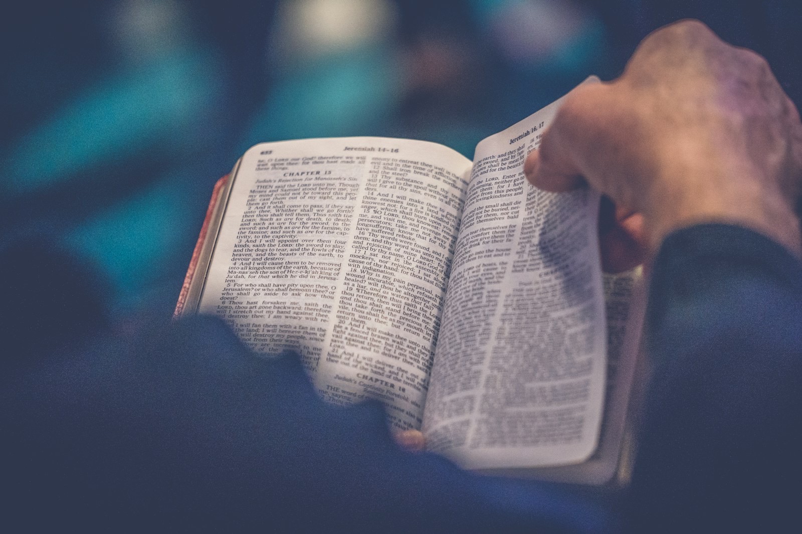 A hand holding an open Bible