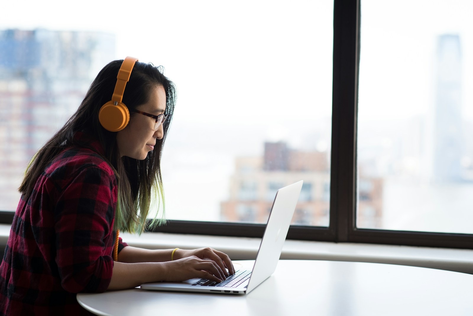 A team at laptops, one wearing a headset