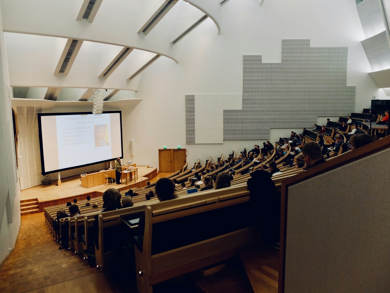 A tiered lecture hall facing a projection screen